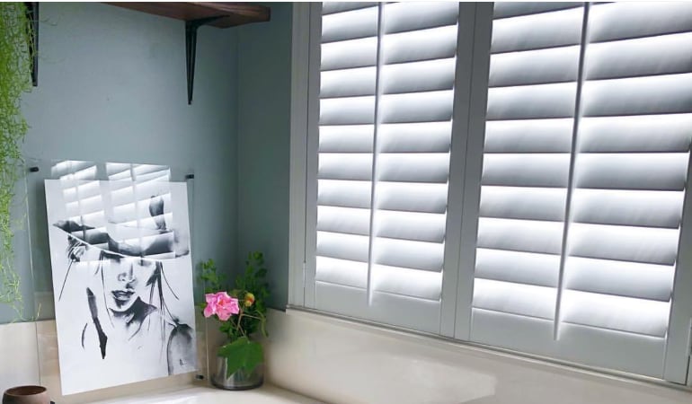 Plantation shutters over a bathroom window.